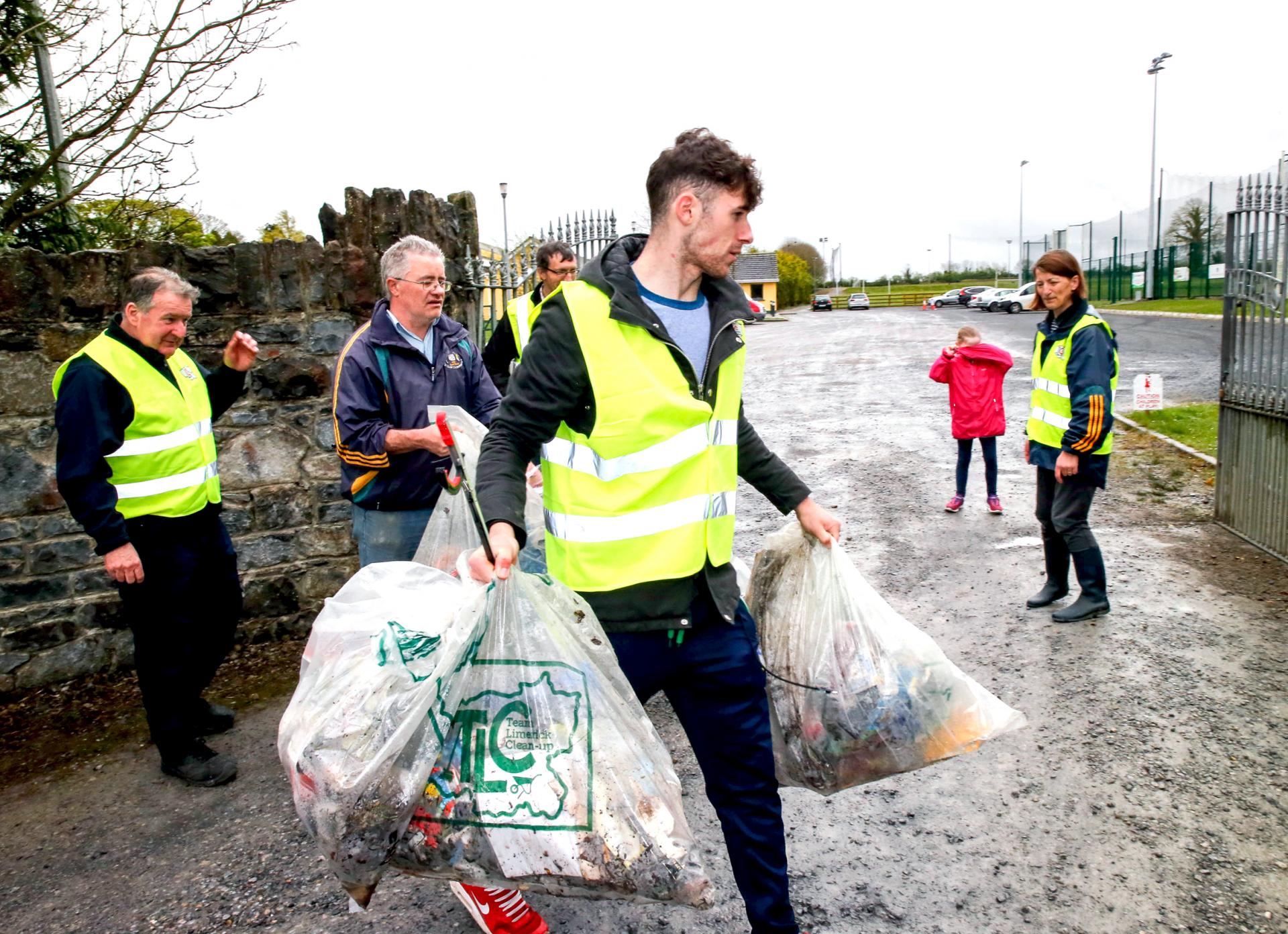 A man carries bags with a clean-up group at South Liberties GAA