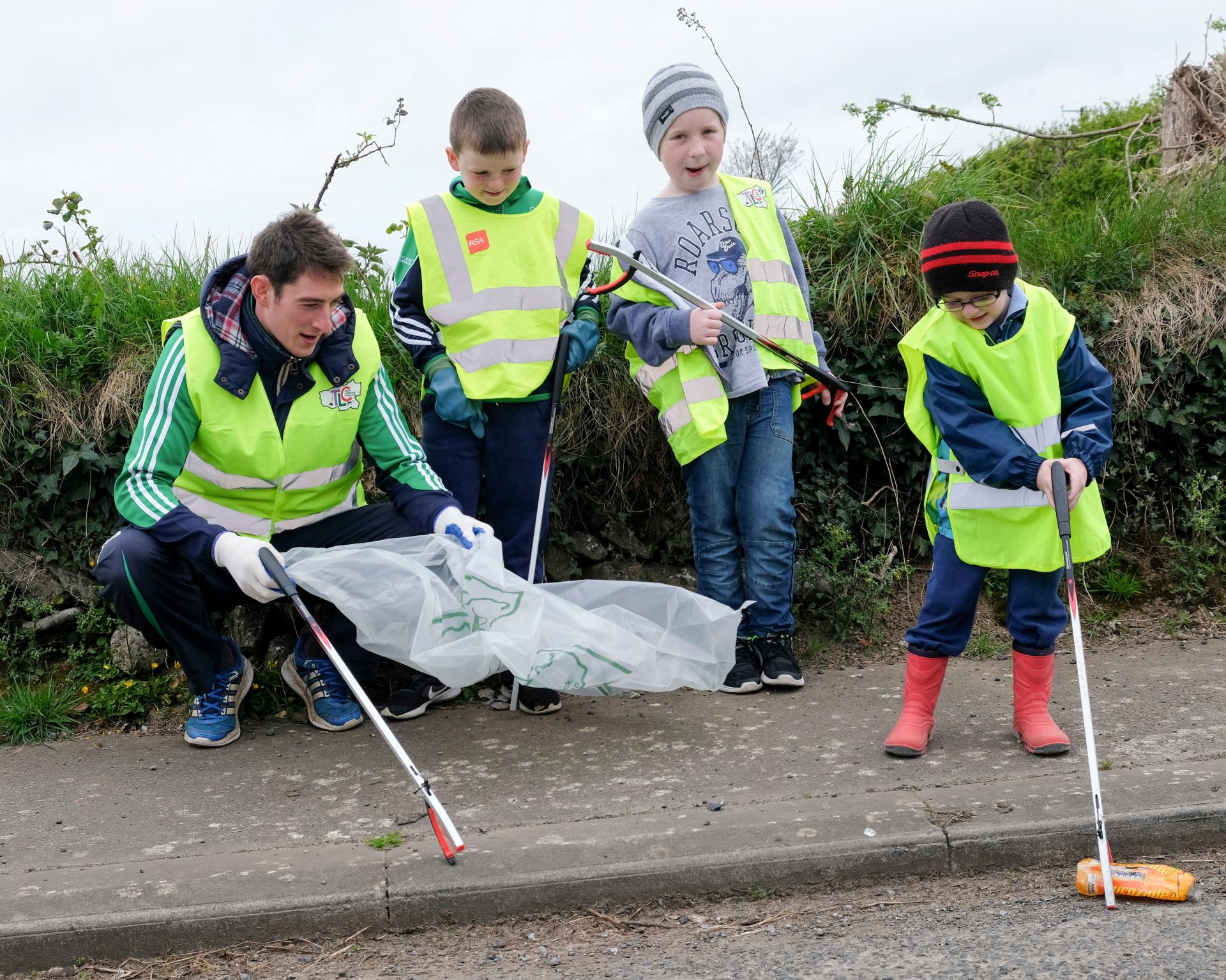 A man and three young kids clean up at Effin