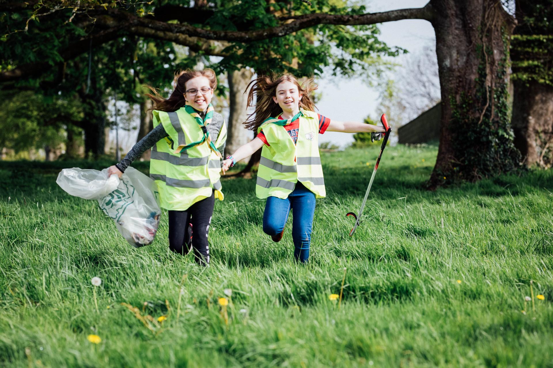 Two girls clean up in a park